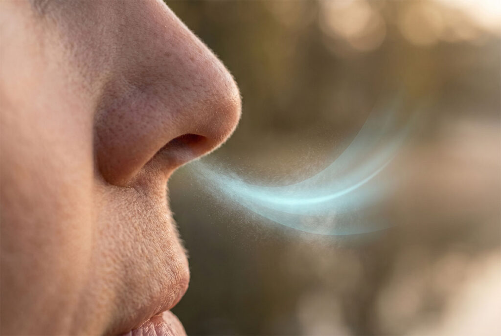 Nahaufnahme einer kontrollierten Ausatmung durch die Nase zur Stabilisierung des CO2-Spiegels.