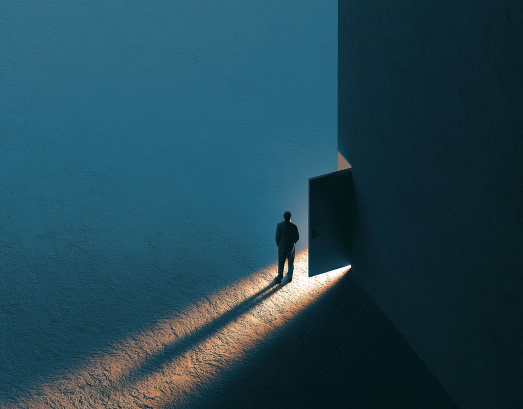 Unflexibles Verhalten ablegen: Warum wir oft so starr reagieren 3 Eine Person steht von hinten fotografiert an einer Weggabelung im nebligen Wald und zögert, einen der beiden Pfade einzuschlagen.