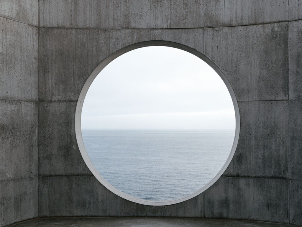 Die Kunst der inneren Freiheit: Warum manche Menschen mühelos loslassen können 2 Massive rohe Betonwand mit einem rundem Ausschnitt, der den Blick auf einen ruhigen nebligen See freigibt.